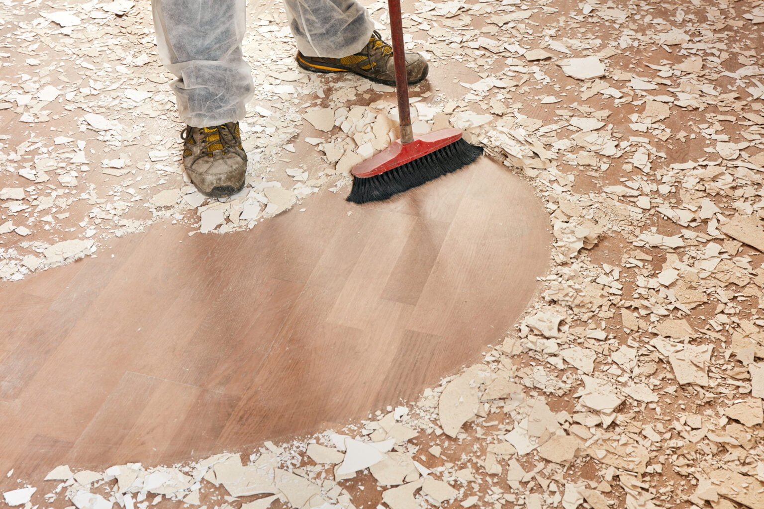 Builder sweeping the floor after renovation