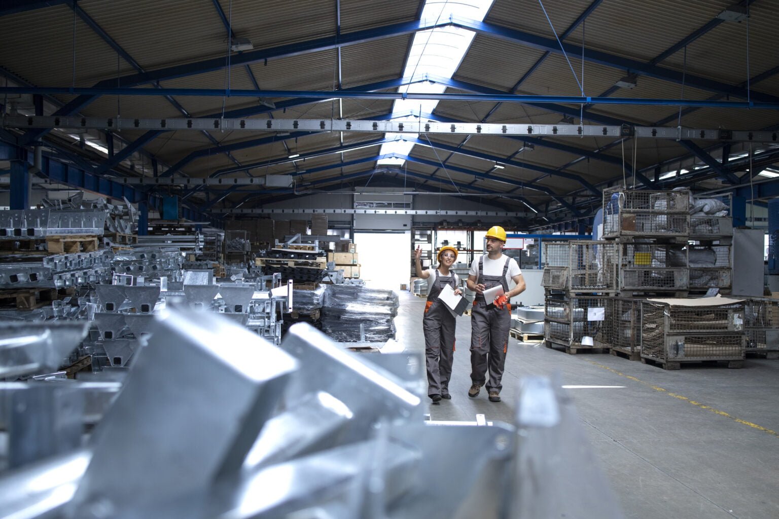 Factory workers in industrial production hall.